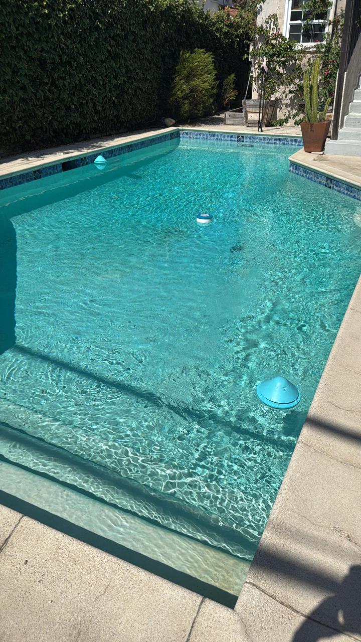 Rectangular lap pool with clear water and floating chlorine dispensers maintained by KLUG Pool Services