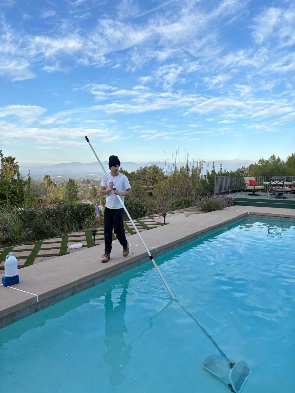 KLUG technician skimming a hillside pool in Los Angeles County